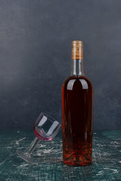 Foto grátis garrafa de vinho tinto e copo na mesa de mármore