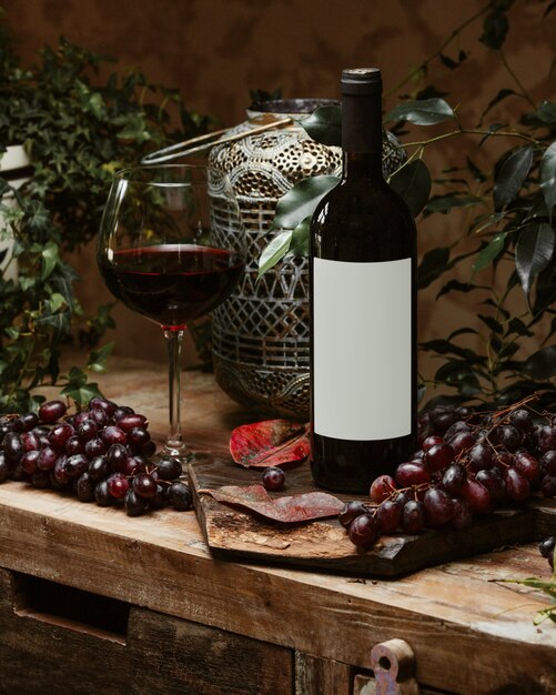 garrafa de vinho tinto e um copo de vinho tinto em estilo rústico