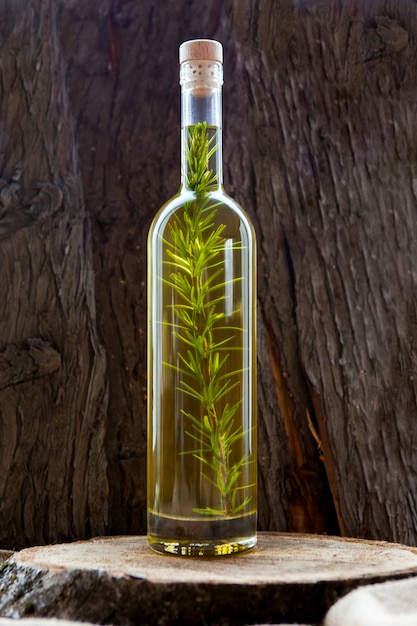Garrafa de vista lateral com azeite de oliva na mesa de madeira