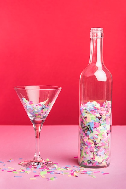 Garrafa e copo com confetes coloridos