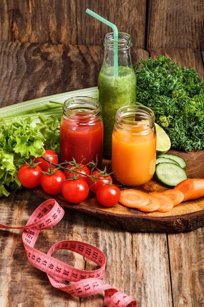 Foto grátis garrafas com sucos de vegetais frescos na mesa de madeira