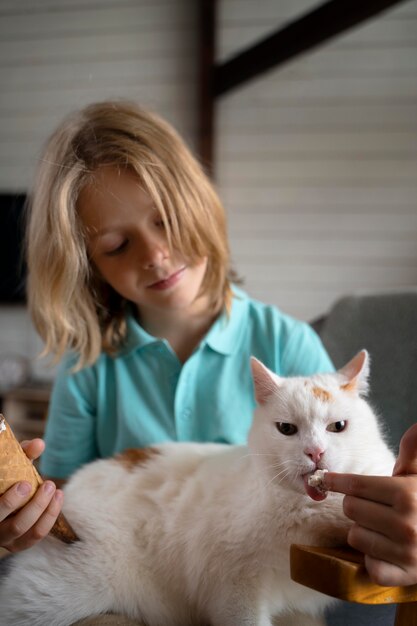 Gato alimentando criança com tiro médio