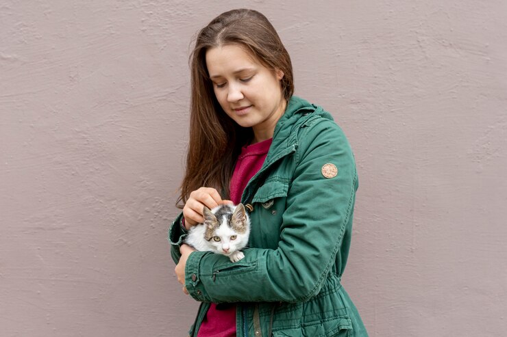 Foto grátis gato de carinho de mulher de alto ângulo