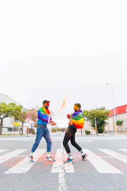 Gays com bandeira de arco-íris encontrando na rua