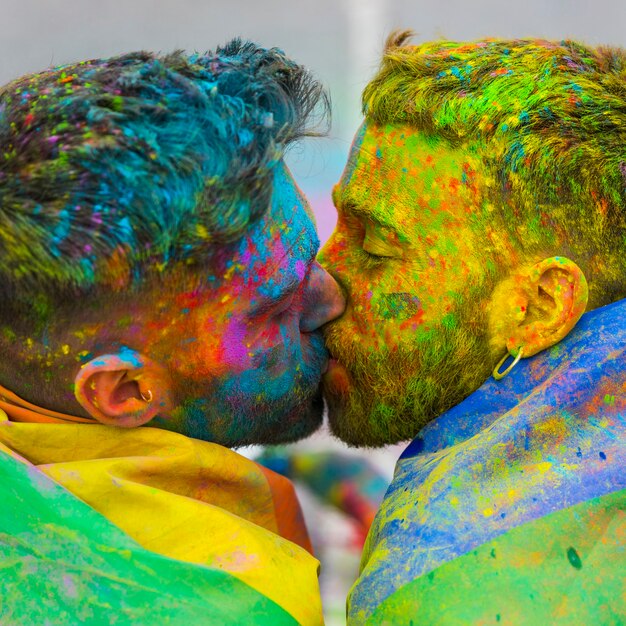 Gays jovens se beijando no festival de Holi cor