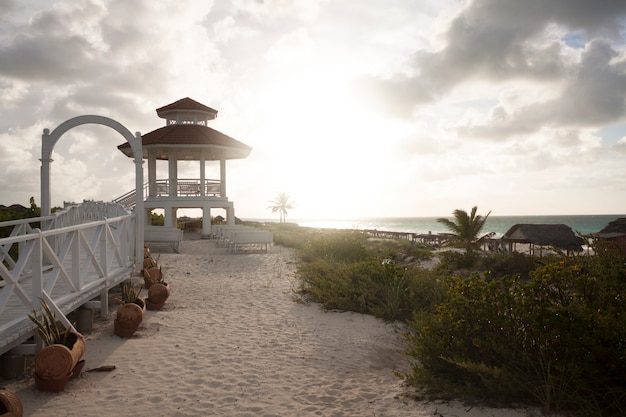 Foto grátis gazebo na praia ao pôr do sol