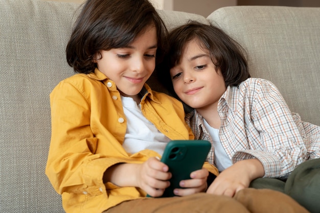Gêmeos brincando em um smartphone