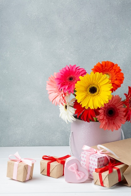 Foto grátis gerbera flores em um balde com presentes