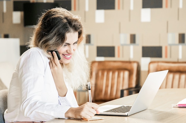 Gerente alegre discutindo projeto com o cliente no telefone