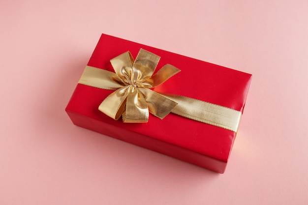 Foto grátis giftbox com fita dourada no fundo rosa