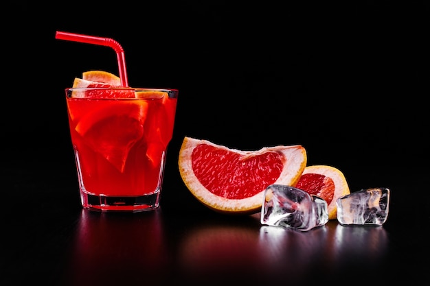 Foto grátis gin, laranja sangue, tônica, coquetel, servido, com, fatias, de, laranja, e, gelo, em, um, vidro
