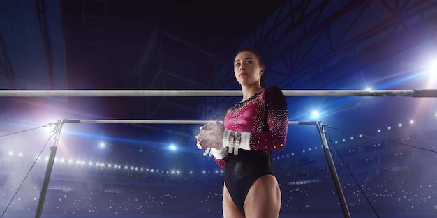 Ginasta feminina fazendo um truque complicado na trave de equilíbrio de ginástica em uma arena profissional
