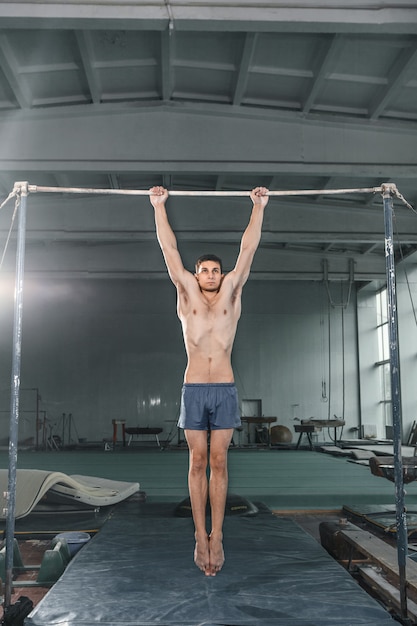 Ginasta masculina realizando o pino em barras paralelas