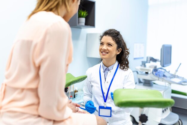 Ginecologista conversando com paciente jovem do sexo feminino durante consulta médica na clínica moderna Paciente com ginecologista durante a consulta no consultório ginecológico