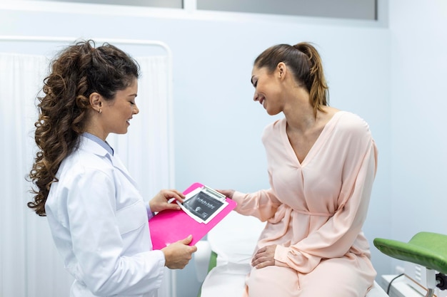 Ginecologista conversando com paciente jovem do sexo feminino durante consulta médica na clínica moderna Paciente com ginecologista durante a consulta no consultório ginecológico