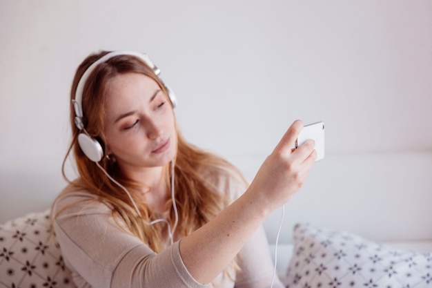 Foto grátis ginger mulher em fones de ouvido tomando selfie