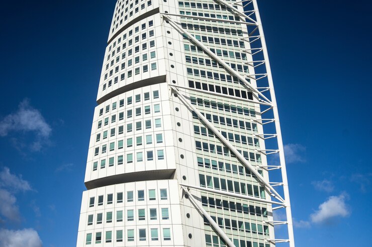 Foto grátis girando o torso sob um céu azul e luz do sol durante o dia em malmo, na suécia
