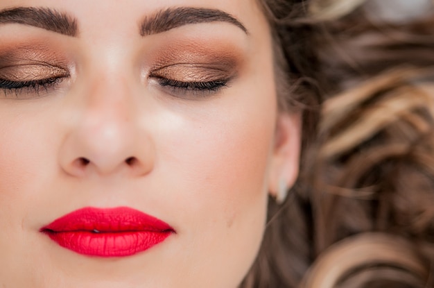 Glamour retrato de modelo de mulher bonita com maquiagem diária fresca e penteado ondulado romântico. marcador brilhante da moda na pele, maquiagem lustrosa lustrosa e sobrancelhas escuras