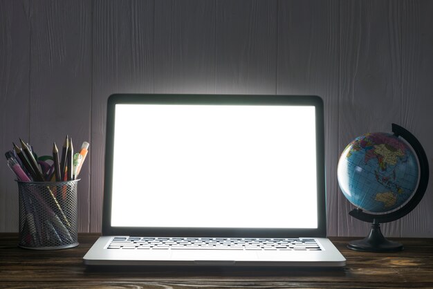 Globo e papelaria perto do laptop