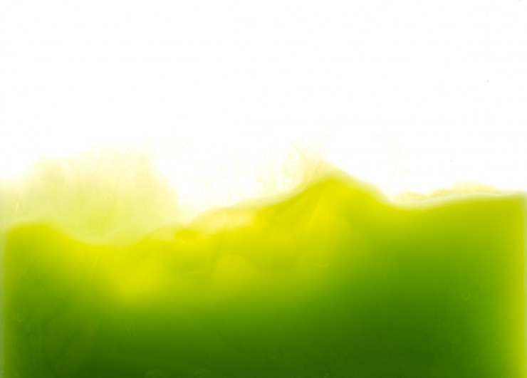 Foto grátis gota de tinta verde que cai na água
