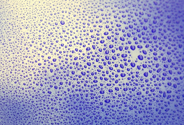 Gotas de água fim acima em uma superfície roxa