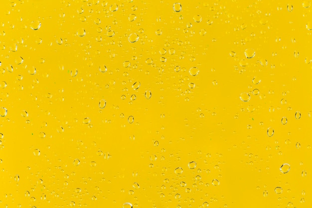 Foto grátis gotas de água na superfície amarela