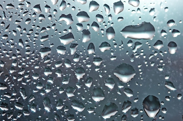 Gotas de chuva de água natural no vidro no fundo da textura abstrata da janela