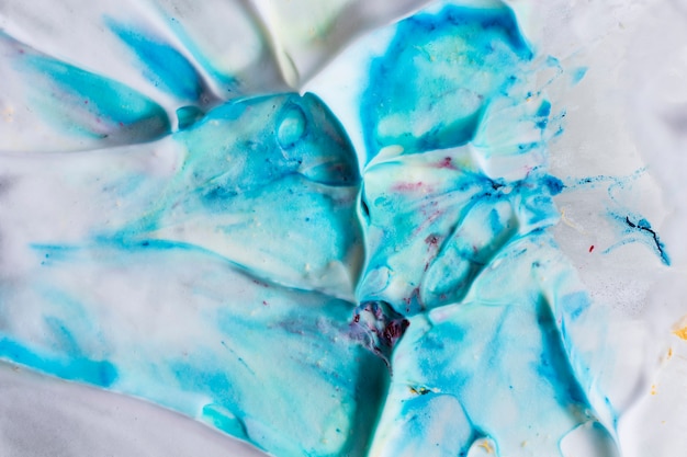 Gotas de cor azul misturam com pano de fundo branco suave espuma