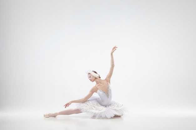 Graciosa bailarina clássica dançando isolada no fundo branco.
