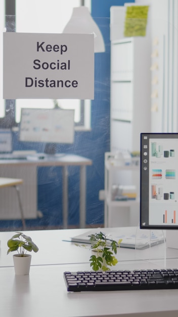 Gráficos de negócios financeiros em um escritório vazio sem ninguém, mantenha as placas de distância social na parede