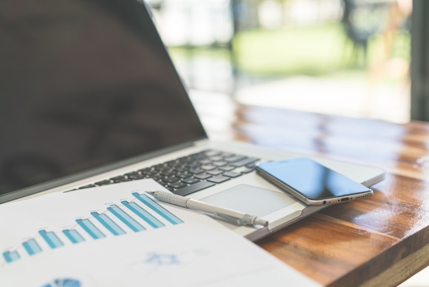 Foto grátis gráficos financeiros sobre a mesa com laptop. (imagem filtrada pr