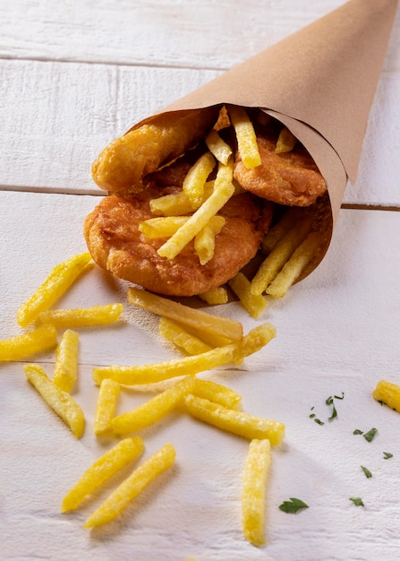 Grande ângulo de peixe com batatas fritas no cone de papel