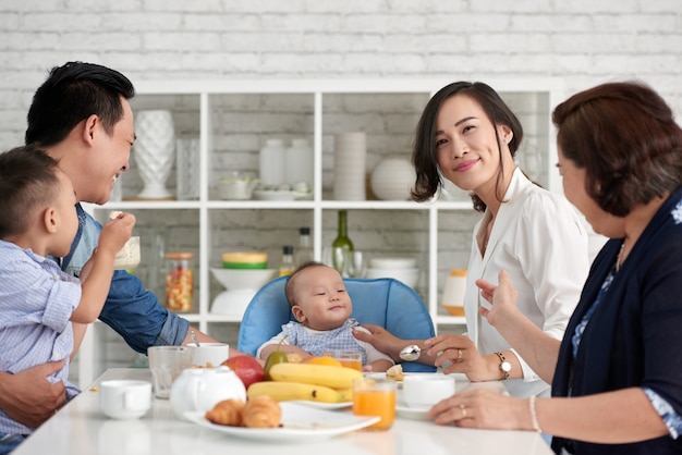Grande família asiática tomando café da manhã
