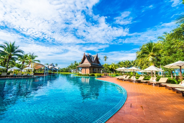 Grande piscina com guarda-sóis e espreguiçadeiras