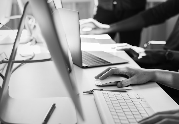 Grande plano das mãos de pessoas trabalhando em computadores