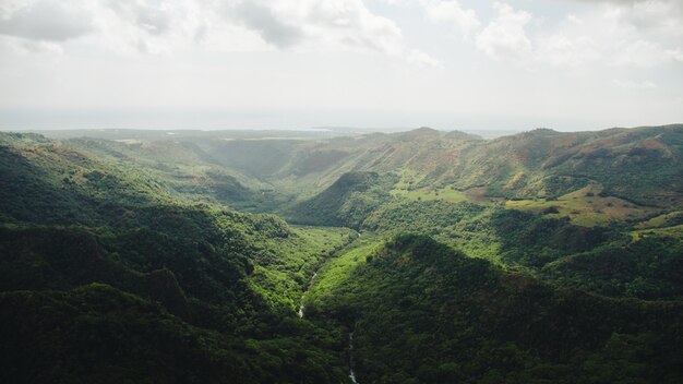 Grande plano do rio atravessando a floresta e as montanhas capturadas em Kauai, Havaí