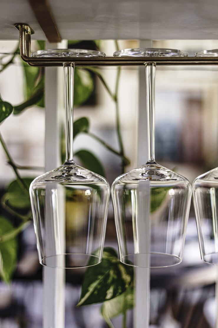 Foto grátis grande plano vertical de taças de vinho penduradas em um suporte