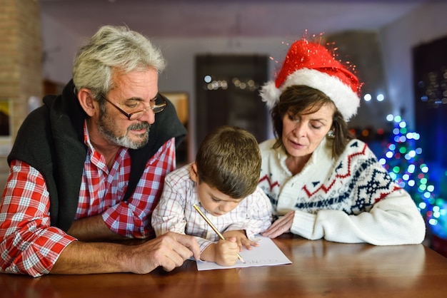 Grandparents com o neto de escrita de Santa carta