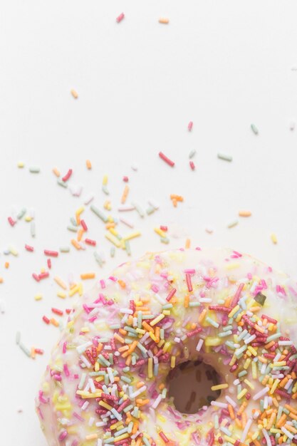 Granulado colorido sobre o donut em pano de fundo branco