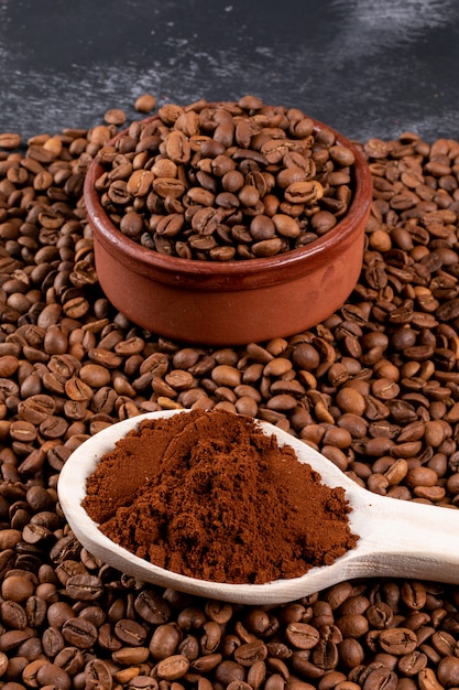 grãos de café com café moído na colher de pau