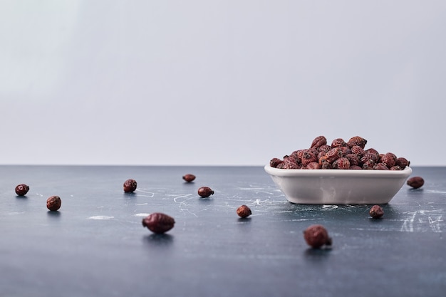 Grãos de café de chocolate em um prato de cerâmica branca.