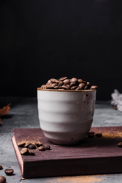 Grãos de café de vista frontal na xícara