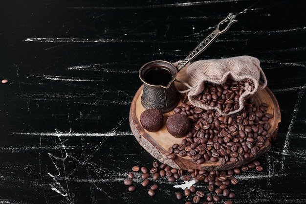 Grãos de café em fundo preto com bombons.