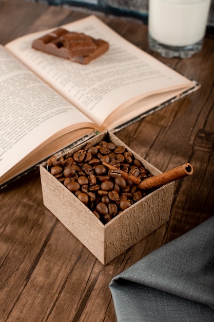 Grãos de café em uma caixa de papelão e um livro
