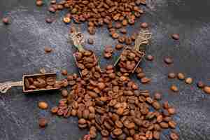 Foto grátis grãos de café na colher de metal na superfície escura