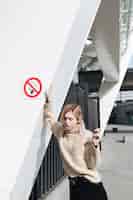 Foto grátis grave jovem loira com cigarro ao ar livre
