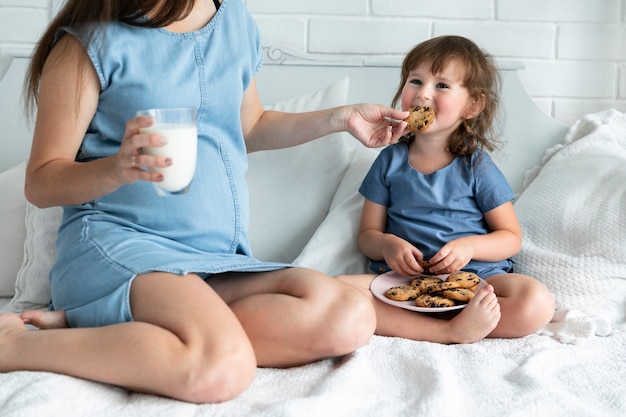 Foto grátis grávida, mãe filha, comer, chocolate, biscoitos