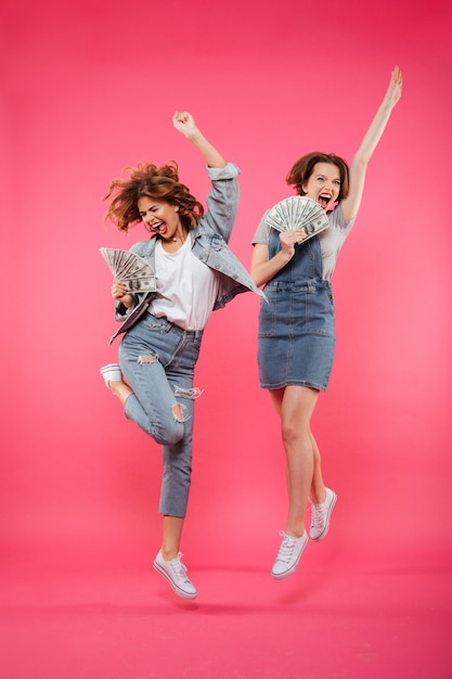 Foto grátis gritando muito duas amigas de mulheres segurando dinheiro