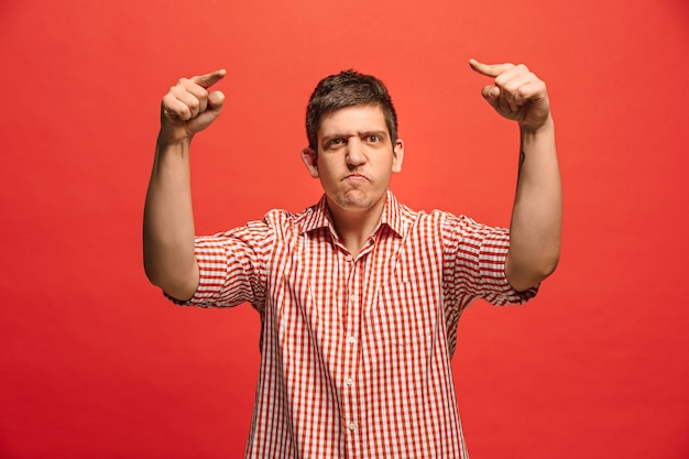 Foto grátis gritos, ódio, raiva. chorando homem irritado emocional, gritando sobre fundo vermelho do estúdio. rosto jovem e emocional. retrato de meio corpo masculino. emoções humanas, conceito de expressão facial. cores da moda