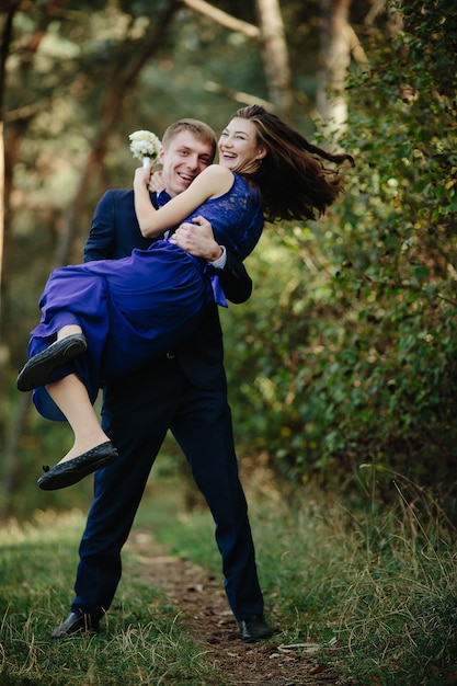 Foto grátis groomsman sorridente carregando madrinha de riso